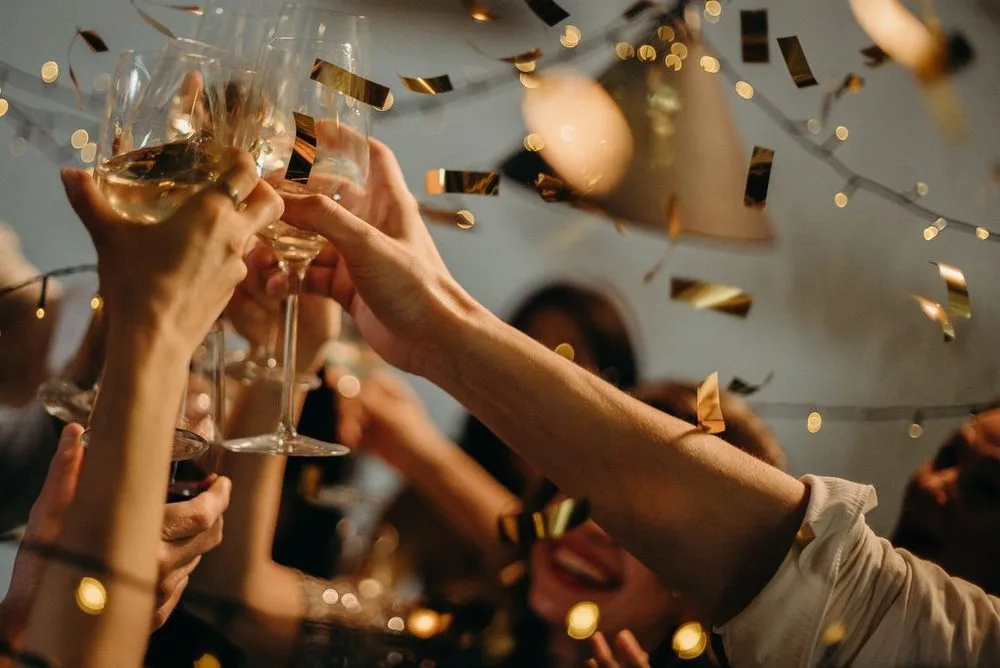 Friends raising glasses in a golden celebration toast