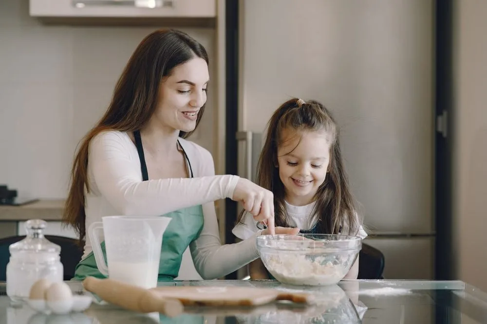 A mother and daughter baking together at home