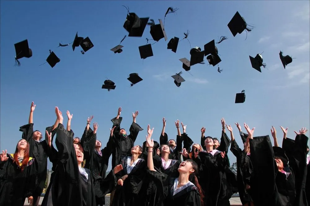 Graduation caps thrown into a clear blue sky